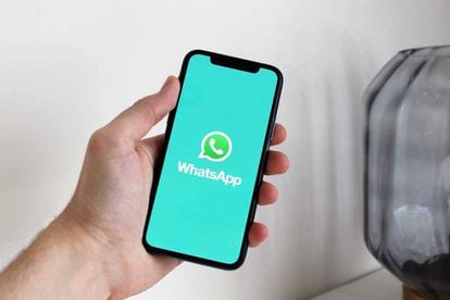 Mobile phone with WhatsApp logo on the screen.