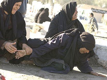 Mujeres iraníes lloran la muerte de sus familiares durante un entierro en fosas comunes en la ciudad de Bam.