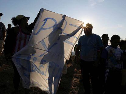 Varios manifestantes sujetan una pancarta pidiendo 'Paz' en la frontera entre Venezuela y Brasil.