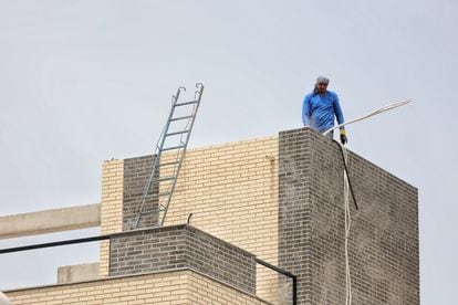 An operator works on the construction of a building in Madrid.