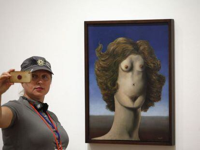Una visitante saca una fotografía frente a 'Le Viol', obra de la exposición dedicada a Magritte.