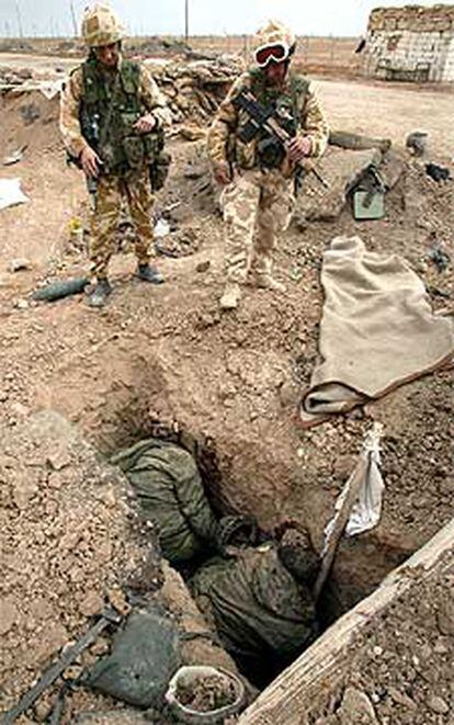 Dos soldados británicos en Fao contemplan a dos iraquíes muertos.