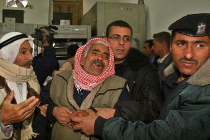 La policía palestina acompaña al padre de tres de los adolescentes muertos en Gaza.