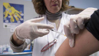 Una enfermera inyecta una vacuna en el brazo de un paciente.