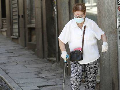 Una persona mayor camina por una calle de Madrid.