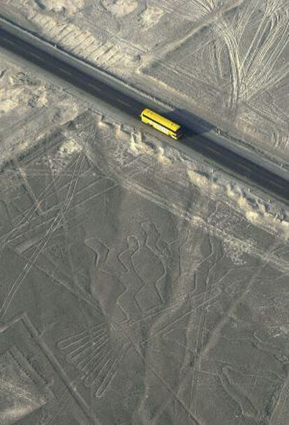 Un autobús pasa ante las líneas de los geoglifos de Nazca por la carretera Panamericana, en Perú.