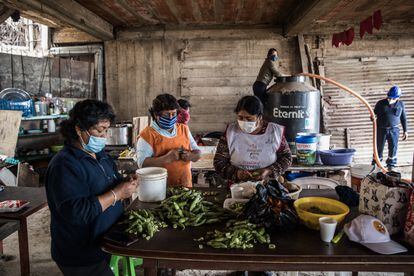 Tres mujeres preparan alimentos en la olla común Ciudad Nuevo Milenio.