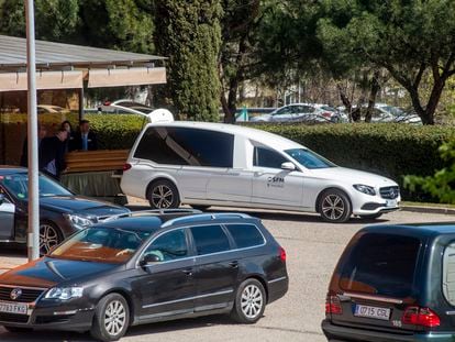 Empleados de la funeraria municipal introducen el féretro de un muerto por coronavirus en un coche, en el Tanatorio Sur de Madrid
