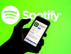 SPAIN - 2021/03/24: In this photo illustration the Spotify app in App Store seen displayed on a smartphone screen and a Spotify logo in the background. (Photo Illustration by Thiago Prudêncio/SOPA Images/LightRocket via Getty Images)