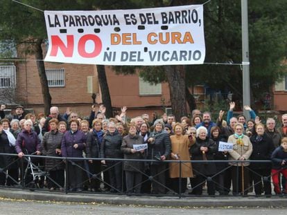 Feligreses católicos de Vallecas posan el último domingo de noviembre bajo una pancarta de protesta.