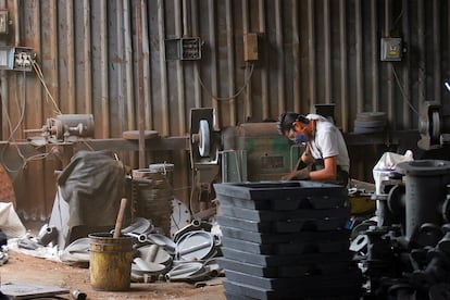 Un trabajador de una fundidora en Jalisco, limpia los moldes de vaciado.