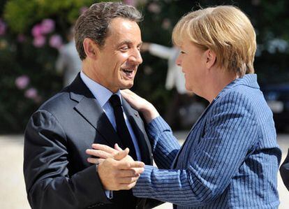 El presidente francés, Nicolas Sarkozy, da la bienvenida a la canciller alemana, Angela Merkel, a su llegada al palacio del Elíseo, en Paris, para mantener un encuentro bilateral sobre la crisis de la zona euro.