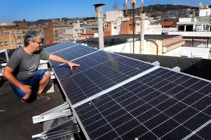 Eduard Moreno, ante los paneles fotovoltaicos que ha instalado en la cubierta del edificio donde vive, en el barrio de Gràcia de Barcelona.