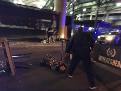 Uno de los sospechosos de los ataques terroristas permanece tumbado en el suelo tras ser reducido por la policía en Borough Market, en Londres.