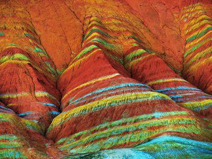 Parecem ondas pintadas no declive da montanha, mas na verdade trata-se de camadas de sedimentos de arenito e minerais que se depositaram nessa região do norte da China há mais de 24 milhões de anos, que foram modelados pelos movimentos tectônicos e pela erosão. Constituem o elemento mais característico do parque nacional geológico de Danxia Landform, na província chinesa de Gansu.