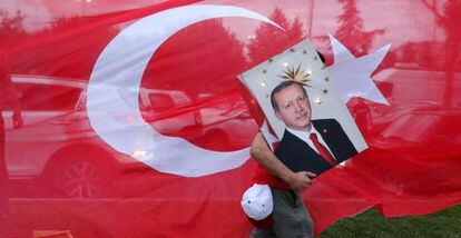 Un seguidor de Tayyip Erdogan, presidente turco, transporta una foto suya, ante la sede del partido AKP, en Estambul.