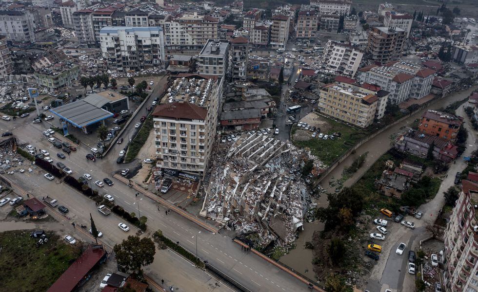 HATAY, TURKIYE - FEBRUARY 06: An aerial view of debris of a collapsed building after 7.7 and 7.6 magnitude earthquakes hits Hatay, Turkiye on February 06, 2023. Disaster and Emergency Management Authority (AFAD) of Turkiye said the 7.7 magnitude quake struck at 4.17 a.m. (0117GMT) and was centered in the Pazarcik district and 7.6 magnitude quake struck in Elbistan district in the province of Kahramanmaras in the south of Turkiye. Gaziantep, Sanliurfa, Diyarbakir, Adana, Adiyaman, Malatya, Osmaniye, Hatay, and Kilis provinces are heavily affected by the earthquakes. (Photo by Ercin Erturk/Anadolu Agency via Getty Images)