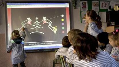 Alumnos de un colegio de Vilassar de Dalt utilizan una pizarra digital.