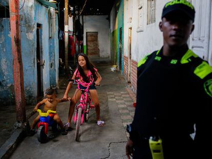 Unos niños juegan en el barrio La Inmaculada, vigilados por un agente de policía.