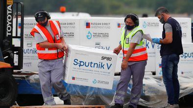 Descarga de cajas con vacunas Sputnik V en el Aeropuerto Internacional Ezeiza, en Buenos Aires (Argentina), el 28 de enero. En video, imágenes de la producción de la vacuna.