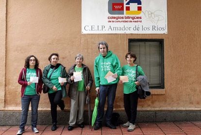Cinco votantes con la prenda de las protestas contra los recortes educativos, en un colegio del barrio de Salamanca.