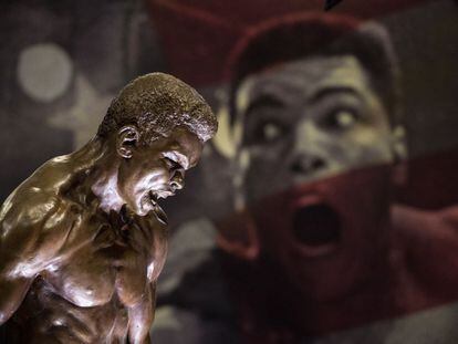 Una estatua de Muhammad Ali frente a una imagen del p&uacute;gil que forman parte de la exposici&oacute;n.  