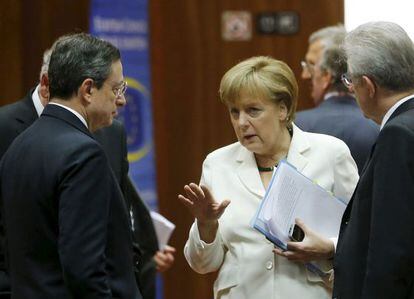 Merkel habla con Monti (derecha) y Draghi, el viernes en Bruselas.