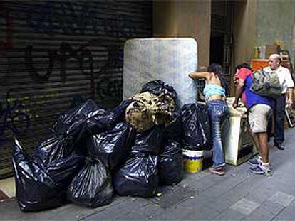 Bolsas de basura, un colchón y muebles, en un tramo de la calle de Sant Pau.
