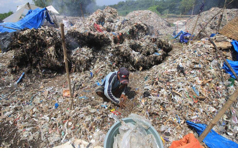 Un hombre rebusca en la basura de plásticos en un vertedero de Tanjang Rono, en Java Oriental (Indonesia).