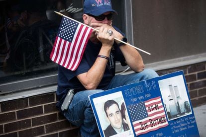 Un hombre sujeta la bandera estadounidense recordando a un fallecido en los atentados del 11 de septiembre de 2001, en Nueva York.