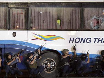 Varios agentes de la policía filipina junto al autobús secuestrado en Manila, antes del asalto