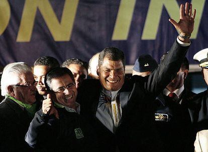 Rafael Correa (derecha) saluda a sus seguidores abrazado al alcalde electo de Quito, Augusto Barreda.