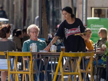 Una camarera atiende una mesa en el barrio del Born (Barcelona).