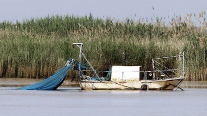 Una barca angulera con las redes caladas y fondeada en el río Guadalquivir.