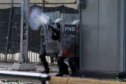 Miembros de la Policía Nacional Bolivariana se enfrentan a manifestantes durante una protesta contra el Gobierno del presidente de Venezuela, Nicolás Maduro, este miércoles en Caracas. El Gobierno chavista, que gobierna el país desde 1999, se ha enfrentado durante la madrugada de este jueves, y por tercer día consecutivo, a protestas de ciudadanos de barrios populares de Caracas, antes considerados bastiones del chavismo.