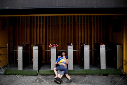 El barrio La Boca, al sur de la ciudad de Buenos Aires, fue la segunda patria de Diego Maradona. En la foto, tomada el 25 de noviembre de 2020, una madre y su hijo se abrazan frente a los molinetes de ingresos de La Bombonera, el estadio de Boca Juniors. Se han enterado hace minutos de la muerte del ídolo.