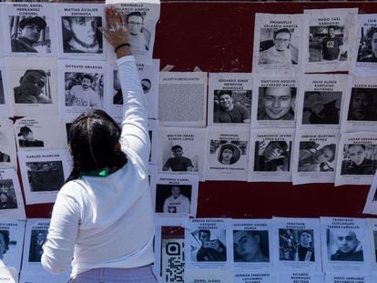 Una activista coloca imágenes de agresores sexuales durante una protesta en el Zócalo capitalino, el 8 de marzo de 2022.