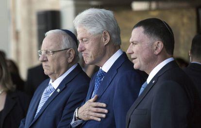 El expresidente estadounidense Bill Clinton (c), acompañado por el presidente israelí, Reuvén Rivlin (i), y al presidente del Knesset, Yuli Edelstein, presentan sus respetos ante el féretro del expresidente israelí Simón Peres, en Jerusalén.