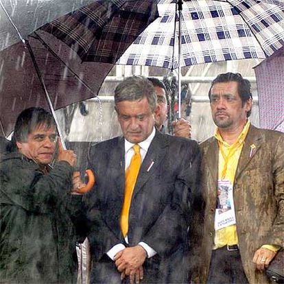 Andrés Manuel López Obrador (centro) es protegido de la lluvia durante su discurso del sábado en México.