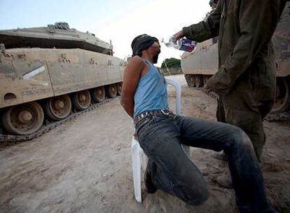 Un soldado israelí da de beber a un prisionero palestino en Jan Yunis, en la franja de Gaza.