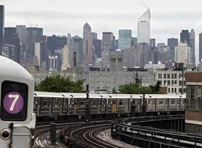 Imagen de Nueva York, con un convoy de metro en primer plano a su paso por el barrio de Queens.