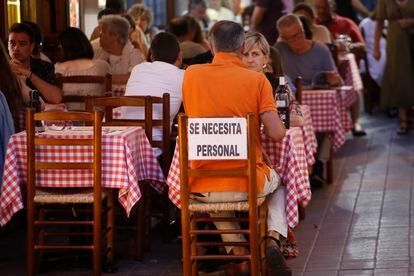 Cartel de "Se necesita personal" en la terraza de un restaurante en Tossa de Mar (Girona).