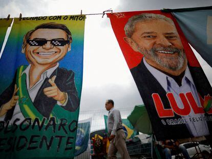 Un hombre camina entre dos imágenes de Jair Bolsonaro y Luiz Inácio Lula da Saliva, el 23 de septiembre, en Brasilia.
