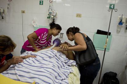 Familiares del policía de Carlos Pineda, de 30 años, llora sobre su cadáver después de ser tiroteado en la cabeza y pasar un día agonizando en la sala de urgencias del Hospital Público de San Pedro Sula, Honduras.