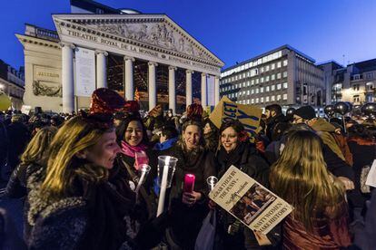 Varios manifestantes sujetan velas durante una protesta en Bruselas, contra Donald Trump. 