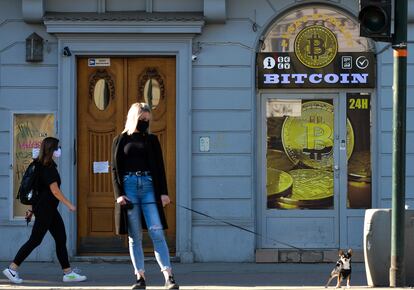 Una mujer pasea frente a una tienda de cambio de bitcoin en el centro de la ciudad de Cracovia (Polonia).