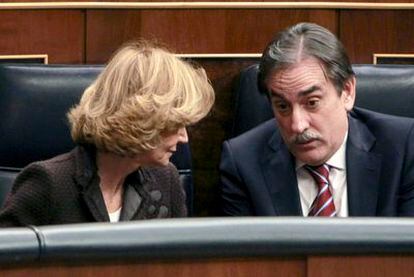 Elena Salgado conversa con Valeriano Gómez en el pleno del Congreso.