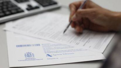 Un contribuyente rellena unos documentos para Hacienda.