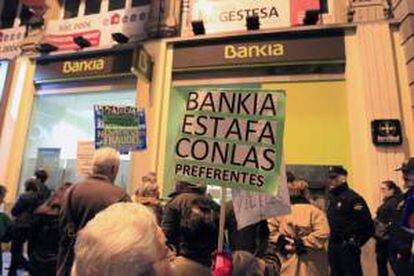 Afectados por las participaciones preferentes ante una sucursal de Bankia. EFE/Archivo