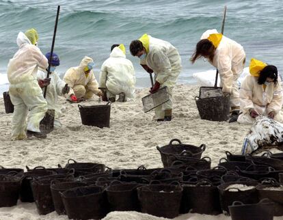 Cientos de voluntarios de toda España recogen el fuel de la playa de Figueiras, de las Islas Cíes, afectadas por el vertido del petrolero Prestige.